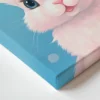 איור דיגיטלי של פני ארנבון תינוק חמוד עם אף ורוד, עיניים כחולות וחיוך עדין, על רקע כחול עם נקודות לבנות.