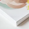 איור של דובי חמוד וחייכן בצבעי פסטל, מחזיק מתנה, בתוך עננים עם כוכבים וקשת בענן ברקע.
