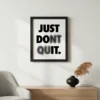 תמונת פוסטר עם מסגרת שחורה, מציגה כיתוב "Just Don't Quit" בפונט לבן על רקע שחור, בעיצוב מינימליסטי.