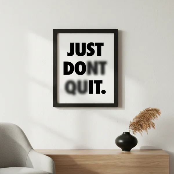 תמונת פוסטר עם מסגרת שחורה, מציגה כיתוב "Just Don't Quit" בפונט לבן על רקע שחור, בעיצוב מינימליסטי.